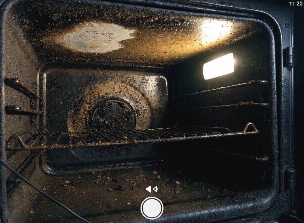 Oven interior, baked-on carbon and spills removed — before