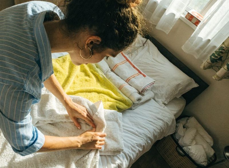 Cleaner folding fresh towels during Recurring Cleaning in Palm Beach, FL