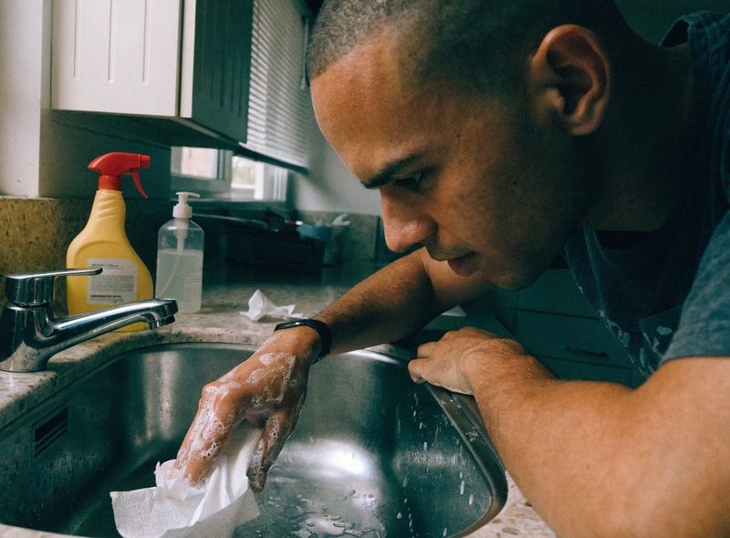 Cleaner sanitizing a kitchen sink during a house cleaning in Palm Beach, FL