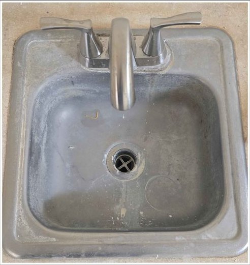 Stainless bar sink, restored to a clean shine — before