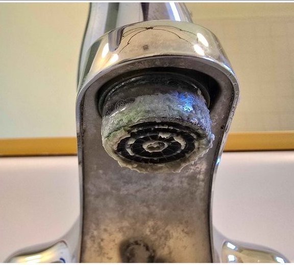 Faucet aerator, scale cleared for better flow — before