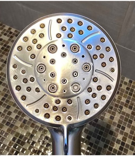 Handheld shower head, hard-water deposit removed — after