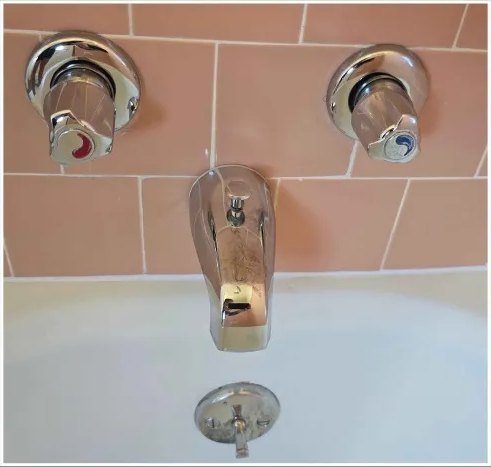 Tub faucet and handles, mineral buildup removed — after