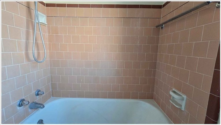 Tile and grout brightened around the tub surround — before